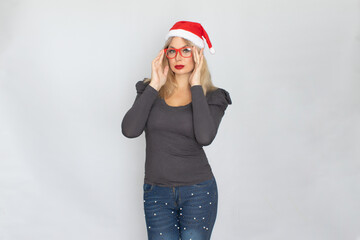 Woman in santa hat and red glasses posing isolated on white background