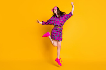 Full size photo of positive lady jumping looking empty space wear cap violet outfit isolated on...