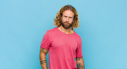 blonde man feeling puzzled and confused, with a dumb, stunned expression looking at something...