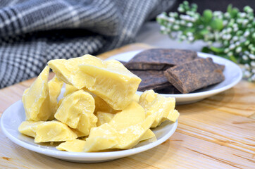 Natural cocoa butter oil in a wooden bowl on a brown background