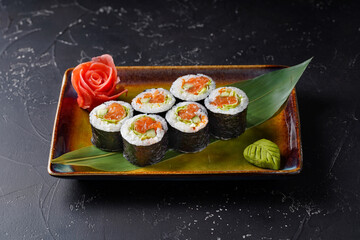 Japan Tokyo sushi roll on dark background with salmon, iceberg lettuce, Japanese mayonnaise, spice