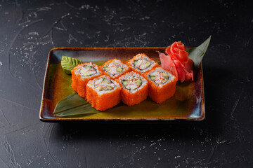 California sushi roll set on a plate on black background. Japanese food.