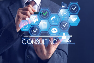 Business consultant with tablet computer using virtual screen on dark background