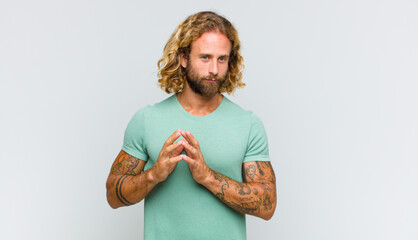 blonde man feeling proud, mischievous and arrogant while scheming an evil plan or thinking of a...