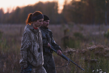 Hunters with guns go hunting. Two hunters cross the field into the forest in search of animals....