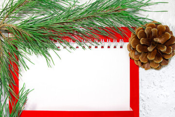 White paper blank for text with fir branch and brown cone on white snowy background. Christmas and New Year's picture. Business sheet. Copy space