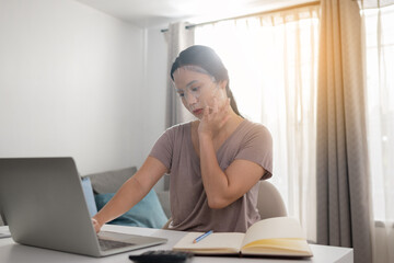Women facial skin care mask while working with laptop at home.