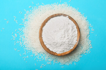 Plate with rice flour on color background