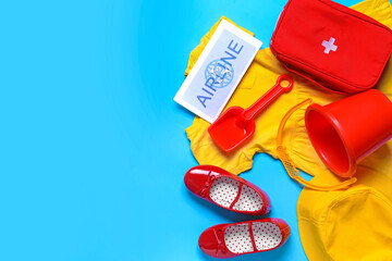 Composition of little girl beach accessories with first aid kit on color background. Travel concept