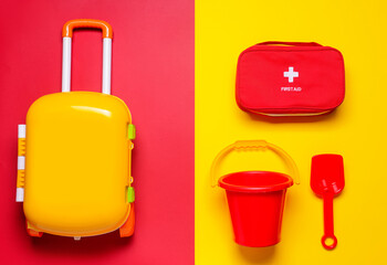Flat lay composition with child beach accessories and first aid kit on color background. Travel concept