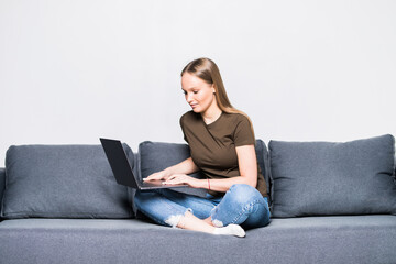Fototapeta na wymiar A pretty woman wearing casual clothes with laptop sit on sofa isolated on white background