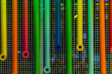 Colorful plastic pipes hanged on metal net