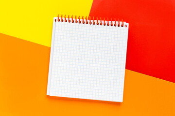 Open blank notepad on bright colored  yellow, red, orange backgrounds. Template with copy space for your text