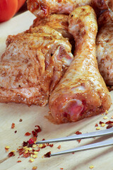pilons de poulet crus, marinés sur une planche à découper