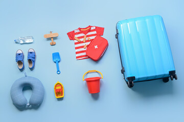 Flat lay composition with little boy beach accessories and first aid kit on color background....
