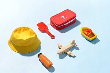 Composition of child beach accessories and first aid kit on color background. Travel concept