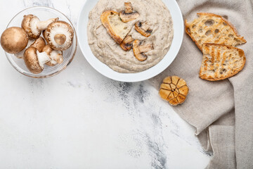 Bowl of tasty mushroom cream soup on light background