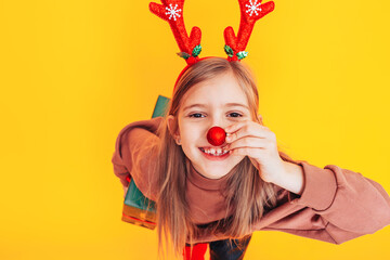 Surprised child holding a large box with a gift. There are Christmas antlers on the head. Christmas...
