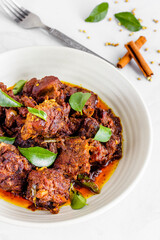 Indian Lamb Masala/Mutton Masala Garnished with Onion, Curry Leaves and Hot Chili Peppers VErtical Photo