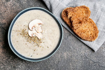 Bowl of tasty mushroom cream soup on  dark background