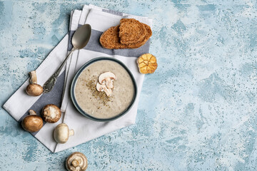 Bowl of tasty mushroom cream soup on  color background