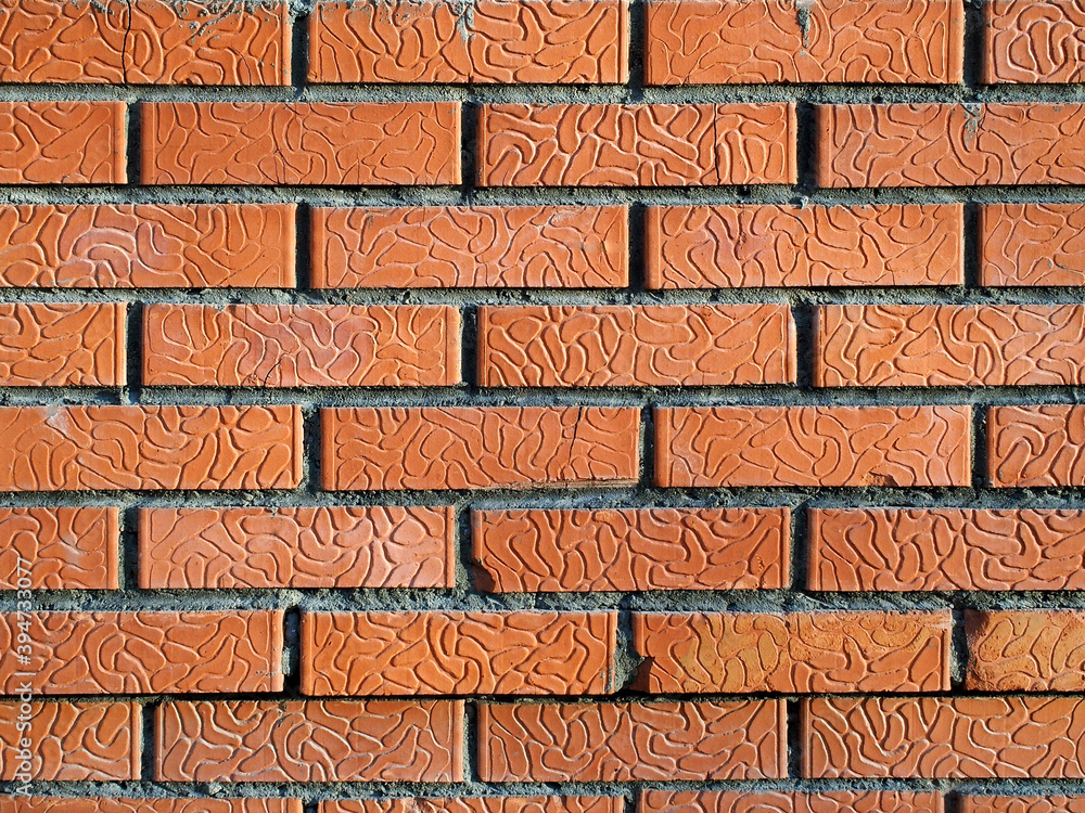Poster the wall is made of decorative red bricks. on the brick, neat grooves are visible, which fold into a