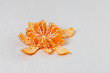 Tangerine in a split peel on a white table.