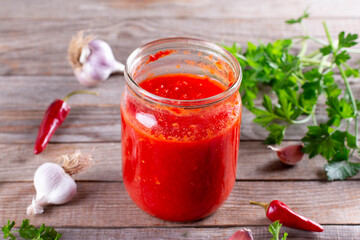 Tomato juice in a glass jar on a wooden background