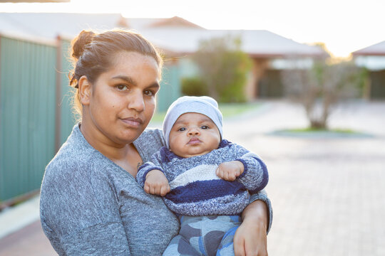 Young mother holding her baby outside