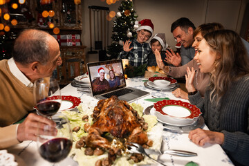A couple on a screen and some relatives celebrating Christmas using a video call. People greeting...