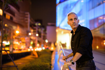 Portrait of attractive man at night on the streets thinking