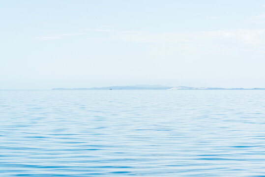 Blue And Blue Sky With Hazy Islands On Horizon