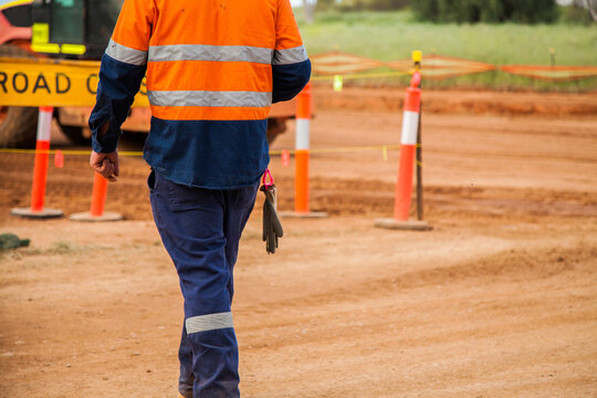 Man in reflective clothing walking around new road construction