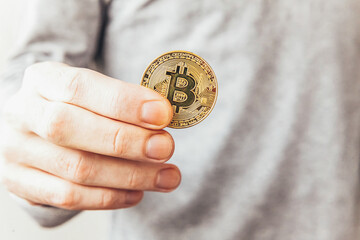 Man hand holding cryptocurrency golden bitcoin coin. Electronic virtual money for web banking and international network payment. Symbol of crypto virtual currency. Mining concept.