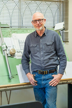 A draftsman standing proudly in front of his drawing board