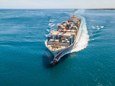 Aerial view of a cargo ship steaming through calm blue water