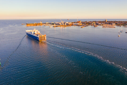 Aerial view of a cargo ship leaving a wake in calm water