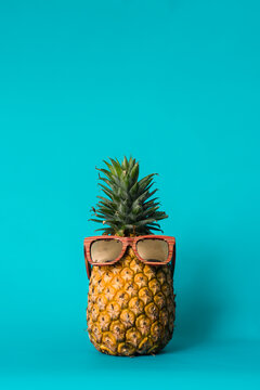 pineapple with sunglasses against a blue background
