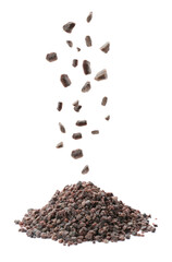 Black salt crystals falling on white background