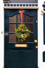 Christmas wreath on entrance vintage door outside. Veranda front door decorated by christmas...
