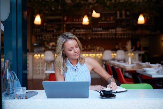 Young woman freelancing from her laptop at cafe