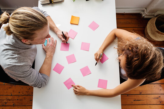 Two people working on a planning session from above