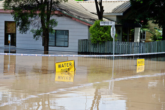 Submerged flood sign reading "water over road"