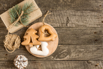 New Year's composition. Gingerbreads, gift wrapped in paper and Christmas decorations on a wooden background. Christmas, winter, new year concept. Flat lay, top view