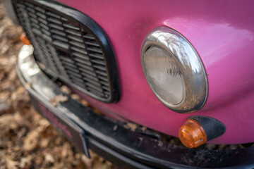 Vintage pink car in autumn surrounding