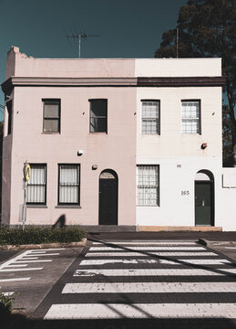 pastel coloured duplex houses overlooking a pedestrian crossing