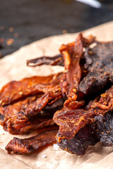 Chicken and beef jerky close-up. Tasty spicy jerky on a dark background, homemade beer snack.