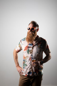 Funky man posing for photographs, holding a glass of beer