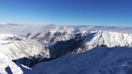 Fototapeta na wymiar View of the snowy Alps. Snowy mountain peaks. Amazing panorama of rocky mountains in winter.