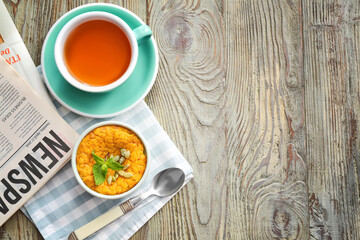 Tasty pumpkin pudding with cup of tea on table